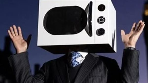 ليس مجنونًا.. رجل يرتدي ميكرويف برأسه ويسير بشوارع بريطانيا لهذا السبب | شاهد